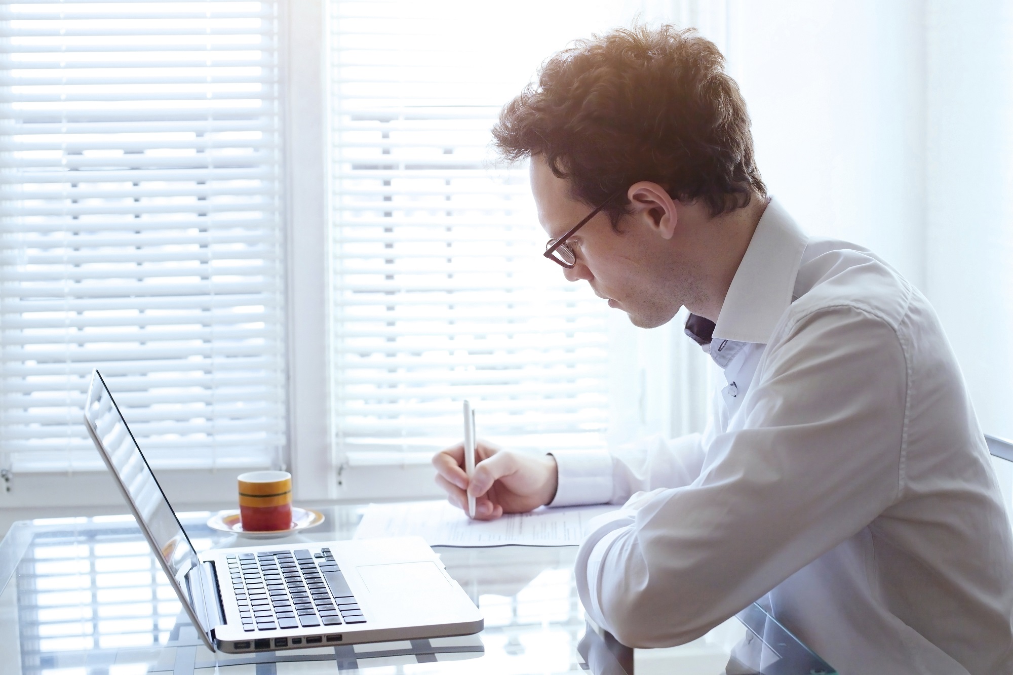 writing resume, young handsome business man working in office