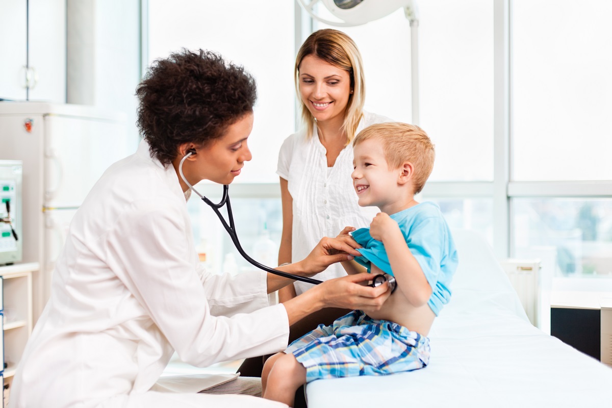 Female doctor examining child with stethoscope