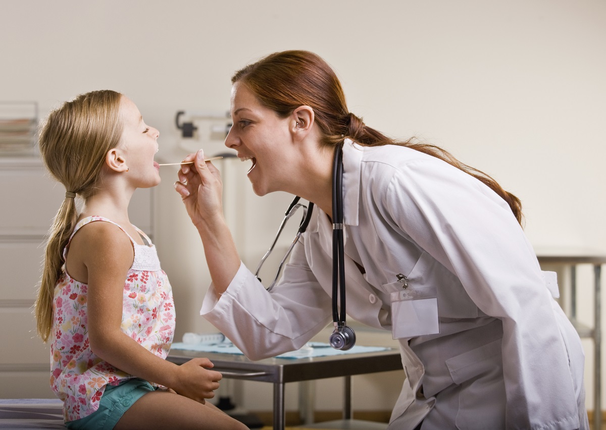 Doctor giving girl checkup in doctor office