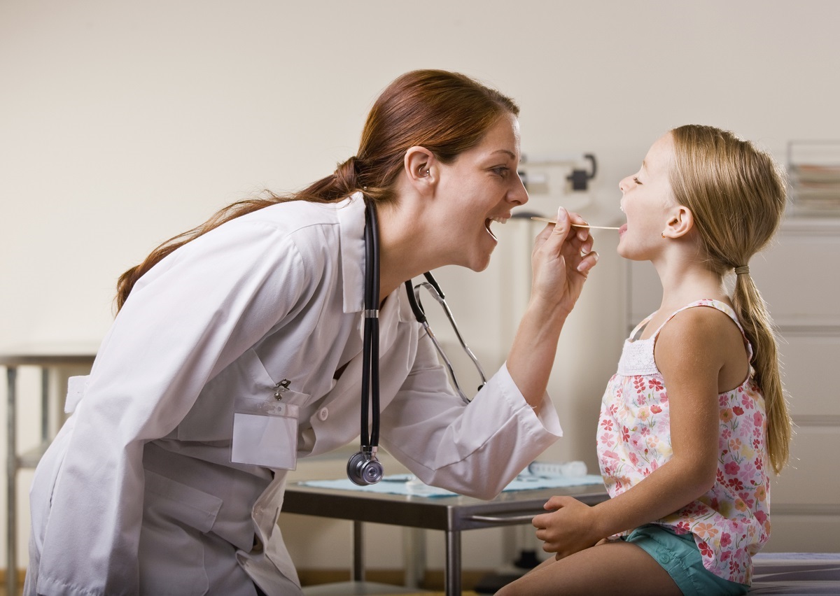 Doctor giving girl checkup in doctor office