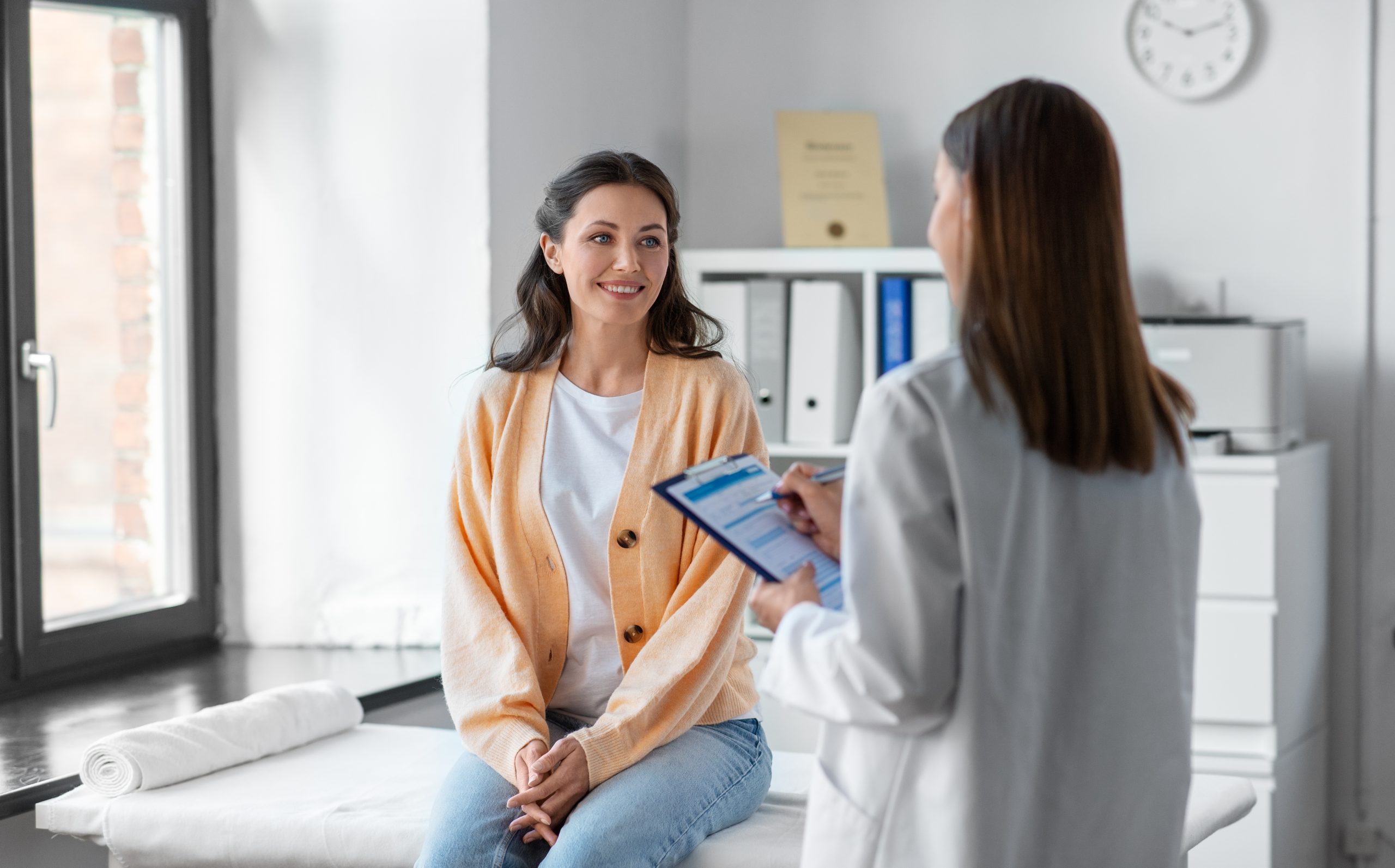 doctor with clipboard and woman at hospital