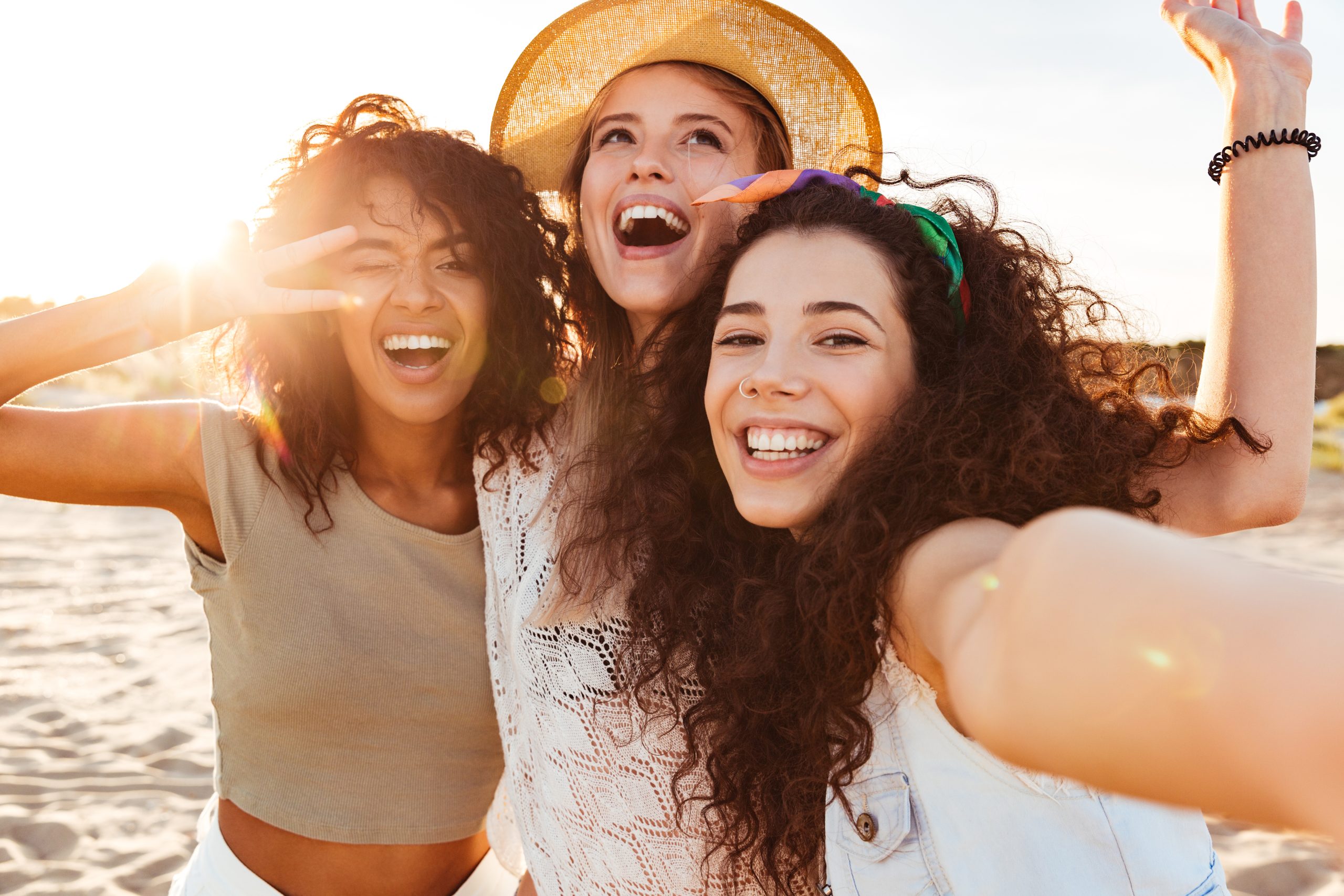 Three cheerful girls friends in summer clothes